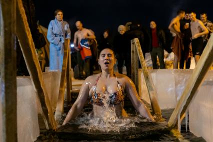 Челябинск. Женщина окунается в купели во время ночных крещенских купаний.