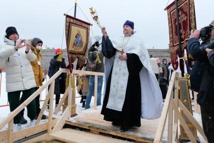 Санкт-Петербург.  Священнослужитель совершает чин освящения воды в купели у Петропавловской крепости.