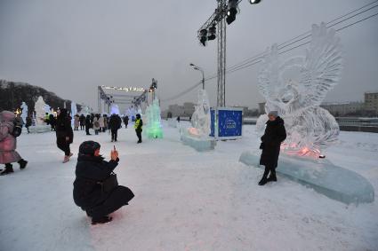 Москва.   Женщины фотографируются  на международном фестивале ледяных и снежных скульптур \"Снег и лед\" в парке Горького.