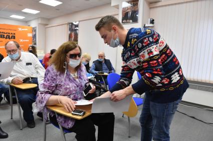 Москва. Волонтер помогает участнице заполнить бланк во время Международной акции`Всероссийский географический диктант-2020` для незрячих и слабовидящих в пресс-центре редакции `Комсомольская правда`.