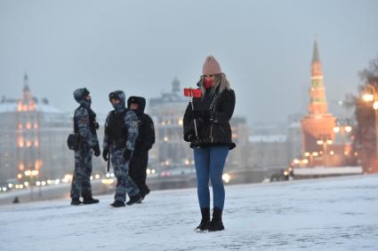 Москва.  Девушка фотографируется на Красной площади.