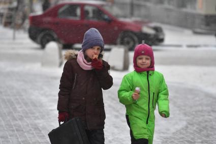 Москва.  Дети едят мороженое на улице.