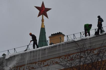 Москва. Сотрудники коммунальной службы чистят крышу здания Арсенала Московского Кремля от снега.