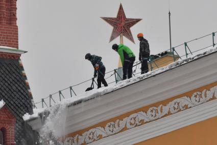 Москва. Сотрудники коммунальной службы чистят крышу здания Арсенала Московского Кремля от снега.