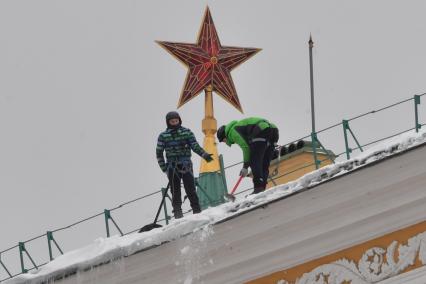 Москва. Сотрудники коммунальной службы чистят крышу здания Арсенала Московского Кремля от снега.