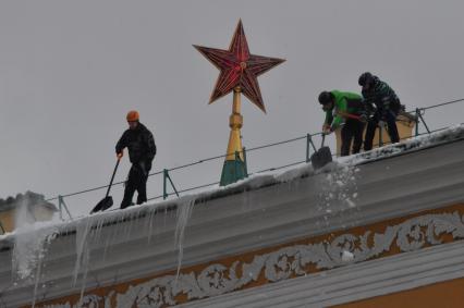 Москва. Сотрудники коммунальной службы чистят крышу здания Арсенала Московского Кремля от снега.