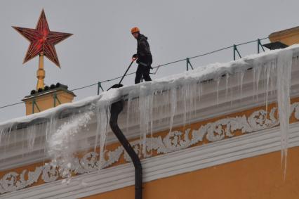 Москва. Сотрудник коммунальной службы чистит крышу здания Арсенала Московского Кремля от снега.