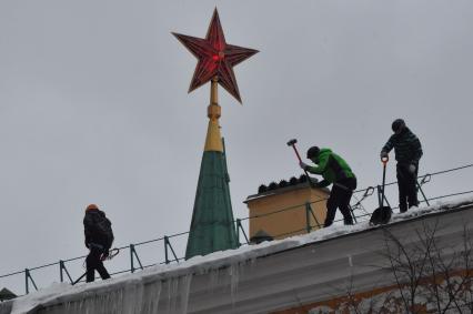 Москва. Сотрудники коммунальной службы чистят крышу здания Арсенала Московского Кремля от снега.