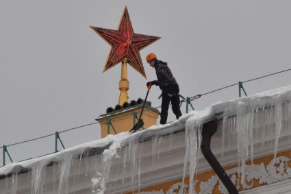 Москва. Сотрудник коммунальной службы чистит крышу здания Арсенала Московского Кремля от снега.