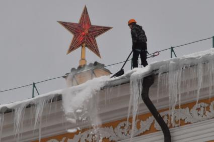 Москва. Сотрудник коммунальной службы чистит крышу здания Арсенала Московского Кремля от снега.