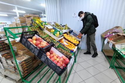 Екатеринбург. Продуктовый магазин. Покупатель в отделе с фруктами и овощами