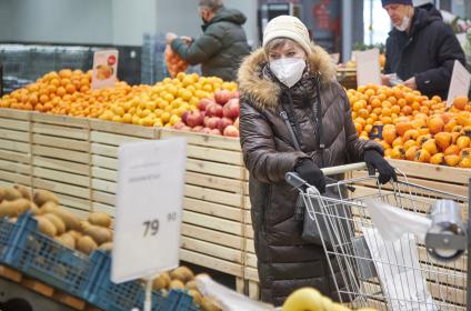 Пермь. Женщина выбирает фрукты в магазине.