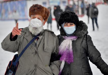 Москва.   Прохожие в защитных масказ на улице города.