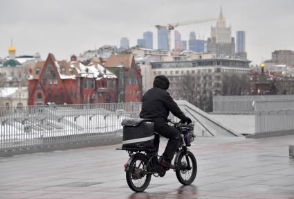 Москва.  Сотрудник службы доставки на велосипеде.