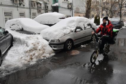 Москва.  Сотрудник службы доставки на улице.