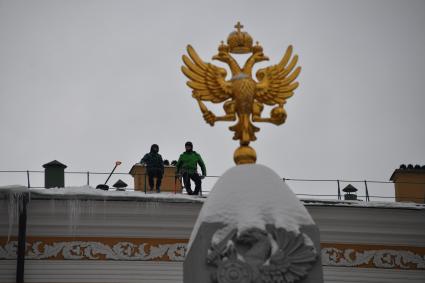 Москва.  Сотрудники  коммунальной службы чистят от снега крышу здания Арсенала Московского Кремля.