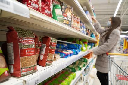 Самара. Девушка у прилавка с крупами в продуктовом магазине.