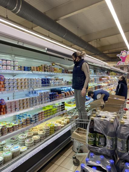 Донецк. Сотрудница раскладывает товары в продуктовом магазине.