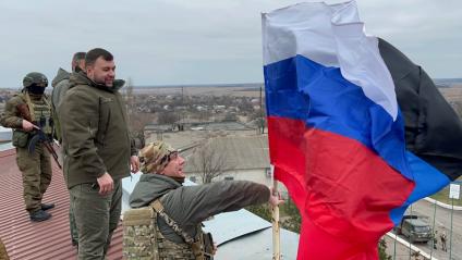 Донецкая область. с.Гранитное. Военная операции РФ по демилитаризации Украины. Глава ДНР Денис Пушилин (второй справа) водружает два флага - России и ДНР на крыше здания администрации освобожденного села.