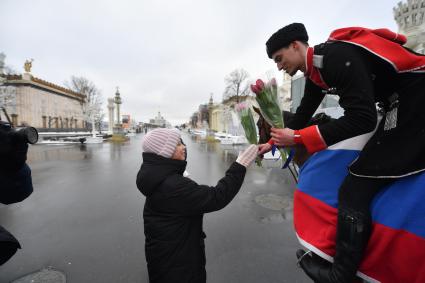 Москва. 8 марта. Всадники Кремлевской школы верховой езды дарят цветы посетительницам ВДНХ на площади Промышленности.