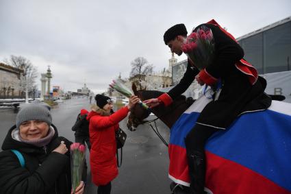 Москва. 8 марта. Всадники Кремлевской школы верховой езды дарят цветы посетительницам ВДНХ на площади Промышленности.