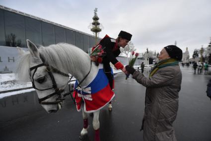 Москва. 8 марта. Всадники Кремлевской школы верховой езды дарят цветы посетительницам ВДНХ на площади Промышленности.