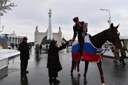 Москва. 8 марта. Всадники Кремлевской школы верховой езды дарят цветы посетительницам ВДНХ на площади Промышленности.