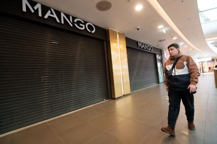 Санкт-Петербург. Мужчина  у витрины закрытого магазина `Mango`.