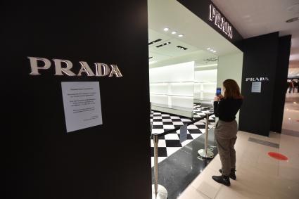 Москва. Девушка фотографирует на мобильный телефон бутик Prada в ЦУМе, закрытый с 6 марта по техническим причинам. Prada приостановил продажи в России из-за военной спецоперации РФ на Украине.