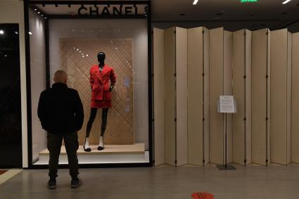 Москва. Мужчина смотрит на манекен в витрине закрытого бутика Chanel в ЦУМе. Chanel приостановил продажи в России из-за военной спецоперации РФ на Украине.