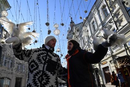 Москва. Молодые люди с белыми голубями на Никольской улице.