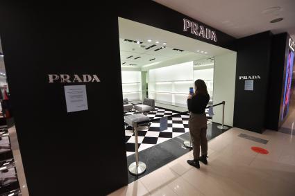 Москва. Девушка фотографирует на мобильный телефон бутик Prada в ЦУМе, закрытый с 6 марта по техническим причинам. Prada приостановил продажи в России из-за военной спецоперации РФ на Украине.