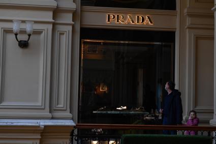 Москва. Мужчина с ребенком идут мимо витрины закрытого бутика Prada в ГУМе. Prada приостановил продажи в России из-за военной спецоперации РФ на Украине.