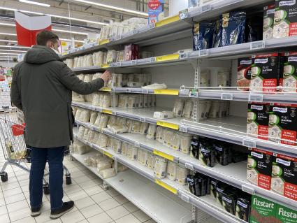 Москва. Покупатель у полок с рисом в продуктовом магазине.