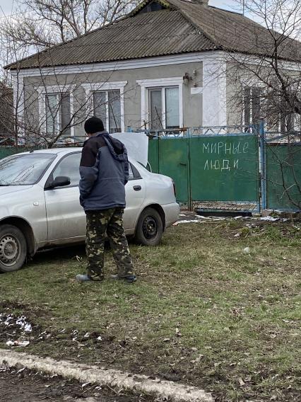 Донецкая область. п.Калиновка. Надпись `Мирные люди` на воротах жилого дома.