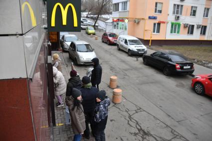 Москва.  Молодые люди у ресторана   Макдональдс на Тверской улице накануне его закрытия.  Рестораны быстрого питания `Макдональдс   приостановливают работу  в России из-за военной спецоперации РФ на Украине.