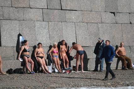 Санкт-Петербург. Люди загорают у стены Петропавловской крепости.