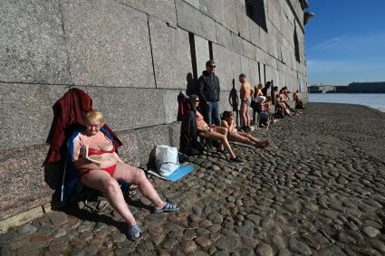 Санкт-Петербург. Люди загорают у стены Петропавловской крепости.