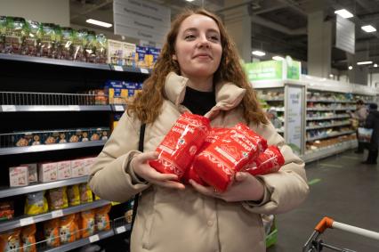 Санкт-Петербург. Девушка держит в руках упаковки с сахаром в продуктовом магазине.