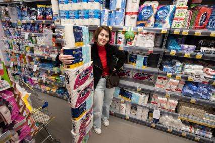 Санкт-Петербург. Девушка с упаковками туалетной бумаги в магазине.
