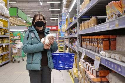 Самара. Женщина держит в руках упаковки с сахаром в продуктовом магазине.