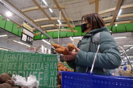 Самара. Женщина выбирает морковь в продуктовом магазине.