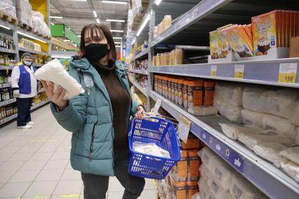 Самара. Женщина держит в руках упаковки с сахаром в продуктовом магазине.