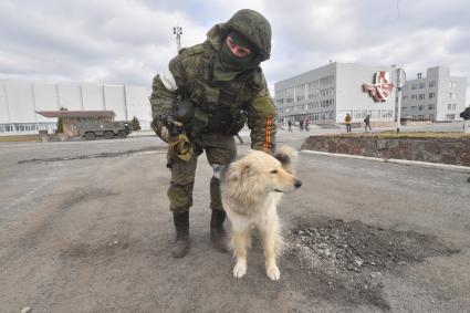 Киевская область. Вышгородский район. Военная операции РФ по демилитаризации Украины. Российские войска контролируют Чернобыльскую АЭС. Военнослужащий гладит собаку.