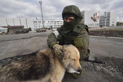 Киевская область. Вышгородский район. Военная операции РФ по демилитаризации Украины. Российские войска контролируют Чернобыльскую АЭС. Военнослужащий гладит собаку.