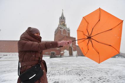 Москва. Девушка с зонтом во время сильного ветра на Красной площади.