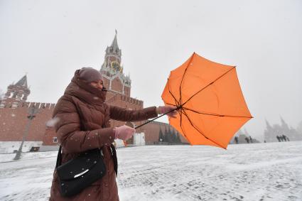 Москва. Девушка с зонтом во время сильного ветра на Красной площади.