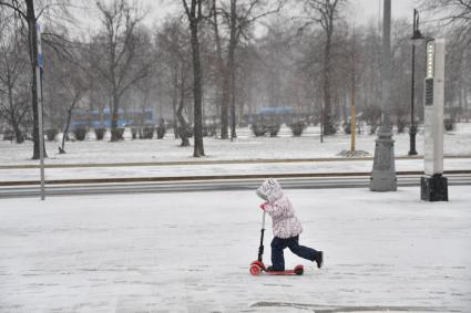 Москва. Девочка катается на самокате.