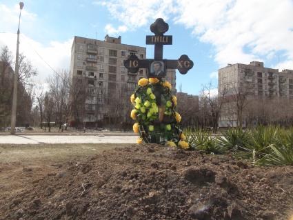 Украина. г.Мариуполь. Местные жители хоронят своих близких в городе. Могила у дороги.