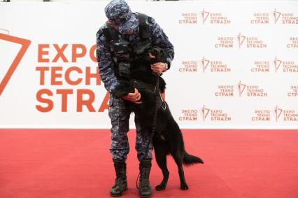 Санкт-Петербург. Сотрудник Росгвардии со служебной собакой на Международной выставке передовых технологий обеспечения безопасности личности, общества и государства `Экспотехностраж-2022` в КВЦ `Экспофорум`.